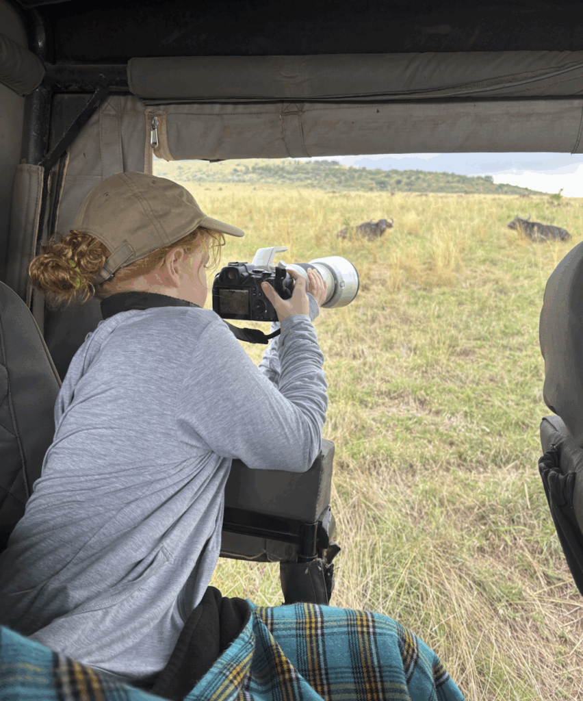 daughter taking pictures of lions and buffalo in masai mara
